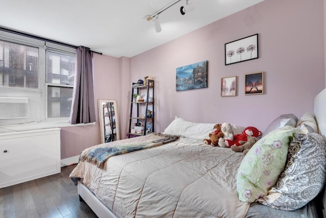 bedroom featuring hardwood / wood-style floors and track lighting