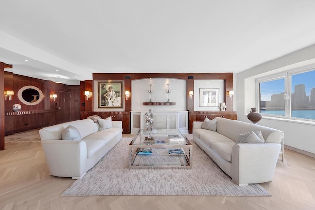 living room featuring a water view, light parquet flooring, and wooden walls