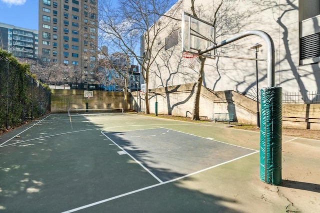 view of sport court with a city view, community basketball court, and fence