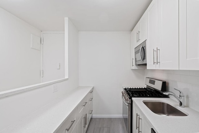 kitchen featuring appliances with stainless steel finishes, sink, white cabinets, and decorative backsplash