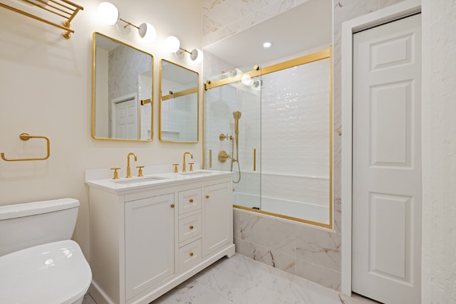 full bathroom featuring toilet, combined bath / shower with glass door, and vanity