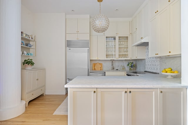 kitchen with light hardwood / wood-style floors, kitchen peninsula, appliances with stainless steel finishes, pendant lighting, and white cabinets