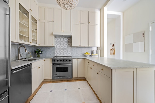 kitchen featuring kitchen peninsula, backsplash, appliances with stainless steel finishes, and sink