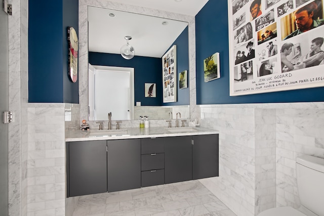 bathroom featuring tile walls, vanity, and toilet