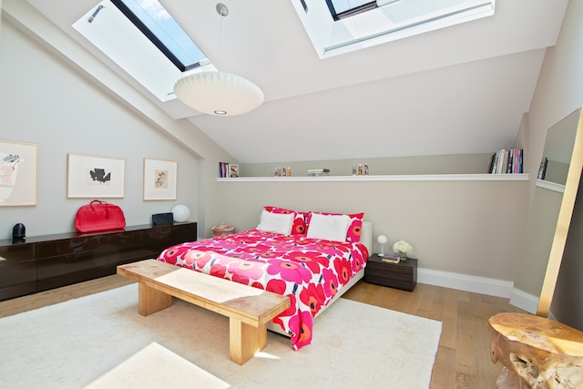 bedroom featuring vaulted ceiling with skylight and light wood-type flooring