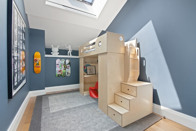 rec room featuring vaulted ceiling with skylight