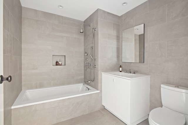 full bathroom featuring tile walls, tiled shower / bath combo, vanity, tile patterned floors, and toilet