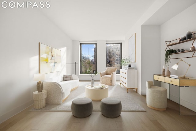 living area with floor to ceiling windows and hardwood / wood-style flooring