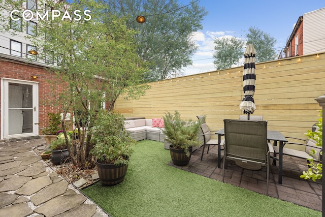 view of yard featuring a fenced backyard, a patio, and outdoor lounge area