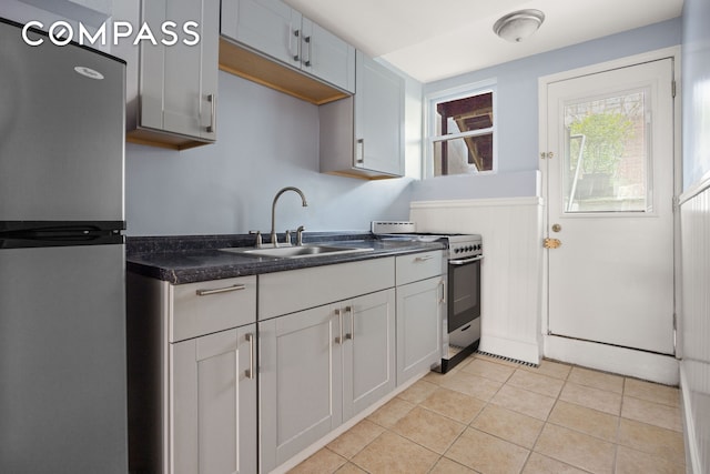 kitchen featuring light tile patterned floors, stainless steel appliances, and a sink