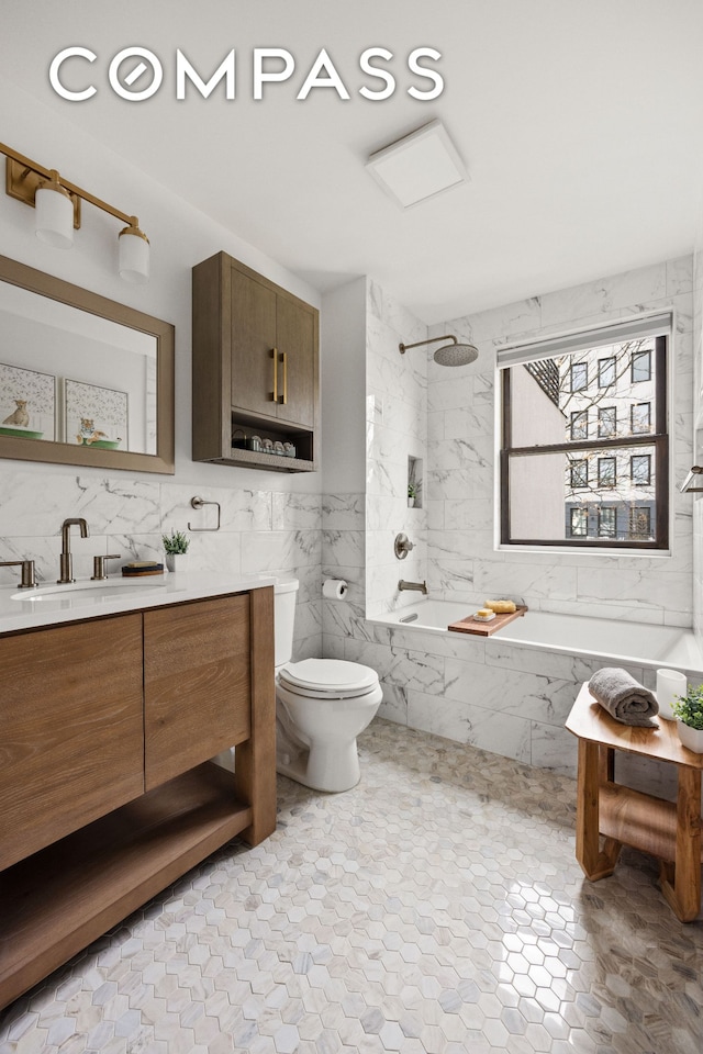 full bathroom with toilet, a combined bath / shower with marble appearance, tile walls, and vanity