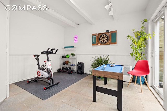 workout area with a wainscoted wall, track lighting, and tile patterned floors