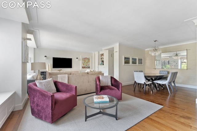 living room with light hardwood / wood-style flooring, ornamental molding, and a chandelier