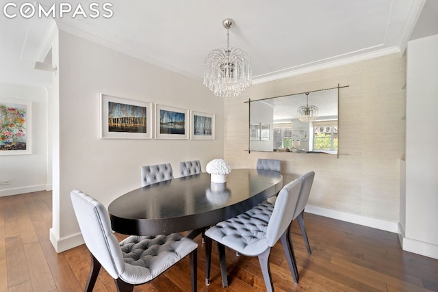 dining space featuring hardwood / wood-style flooring, ornamental molding, and a chandelier