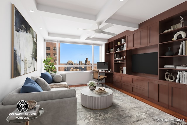 living area featuring beam ceiling, a ceiling fan, and wood finished floors