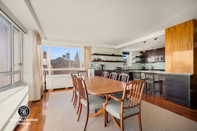 dining room featuring a view of city and dark wood-style floors