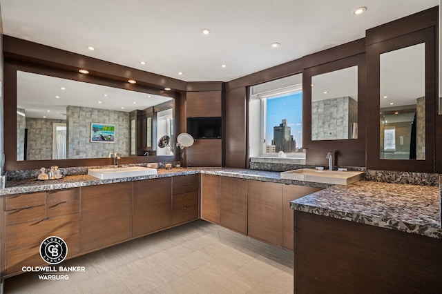 kitchen featuring a sink, modern cabinets, dark stone countertops, and recessed lighting