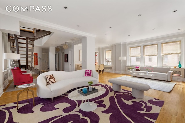 living room with ornamental molding and light wood-type flooring