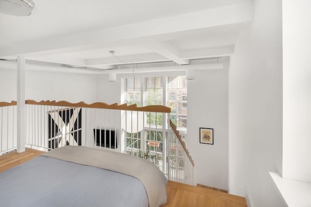 bedroom featuring beam ceiling and wood finished floors