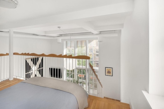 bedroom with hardwood / wood-style flooring and beamed ceiling