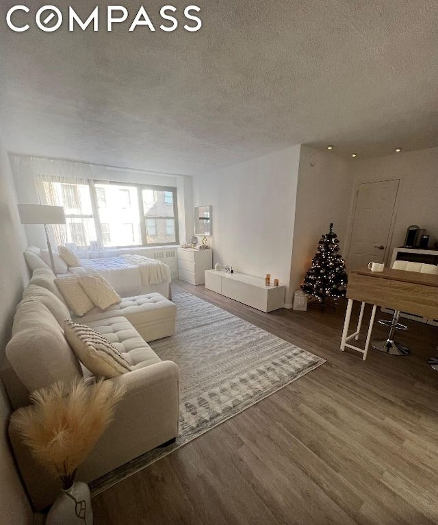 bedroom with hardwood / wood-style floors and a textured ceiling