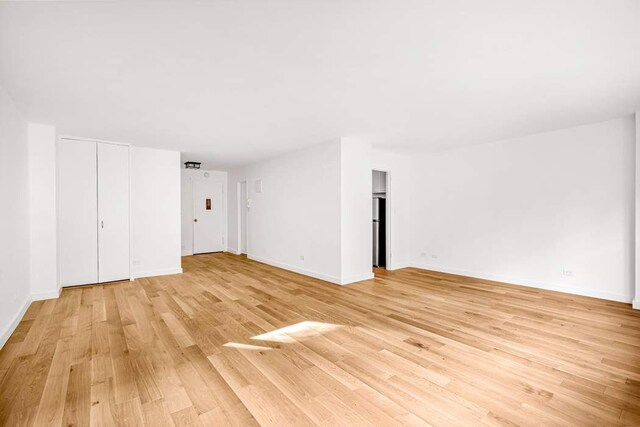 kitchen featuring sink, range, stainless steel fridge, light hardwood / wood-style floors, and white cabinets