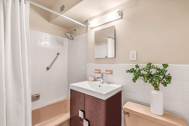 full bathroom featuring shower / tub combo with curtain, vanity, toilet, and tile walls