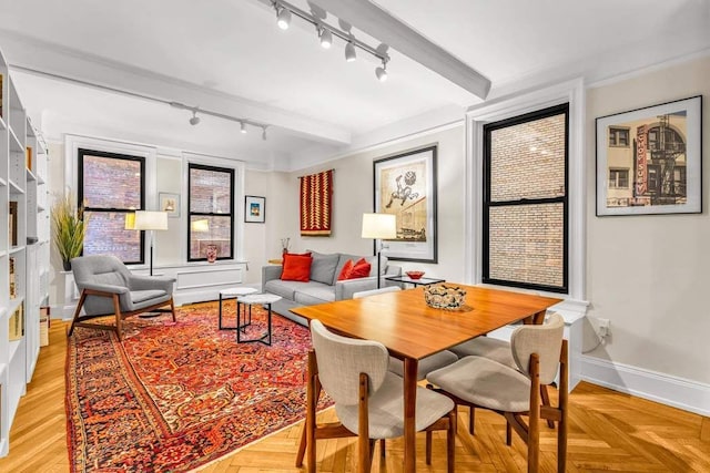 dining area featuring light parquet floors and beamed ceiling