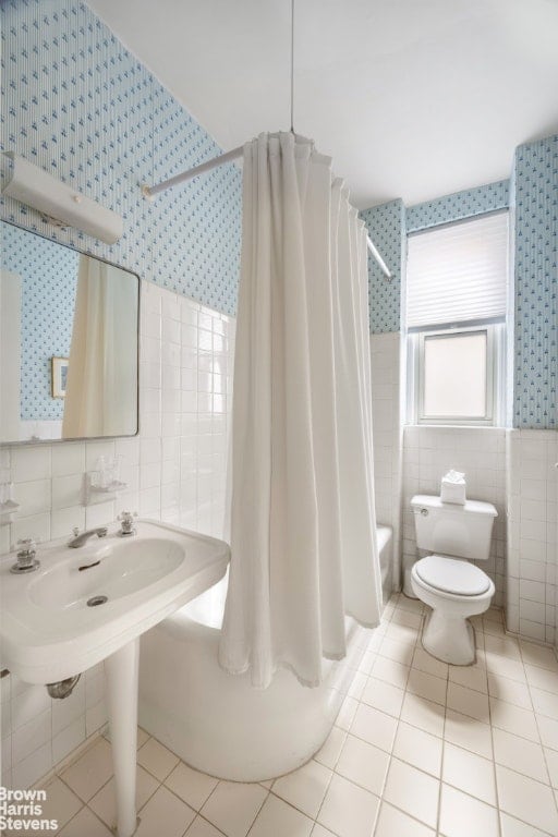 bathroom featuring tile walls, toilet, shower / tub combo, and tile patterned flooring