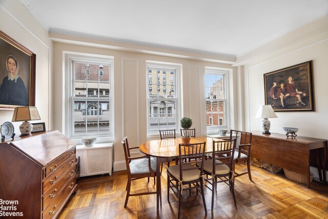 dining space featuring radiator, crown molding, and parquet floors