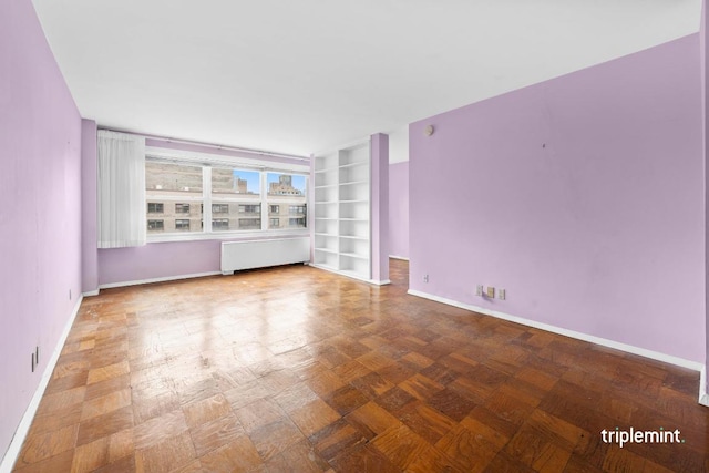 spare room featuring dark parquet flooring