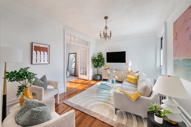 living room with hardwood / wood-style floors and a notable chandelier