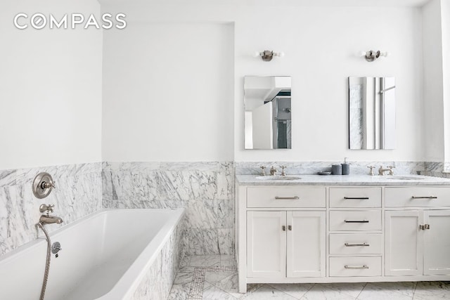 bathroom featuring tiled tub and vanity