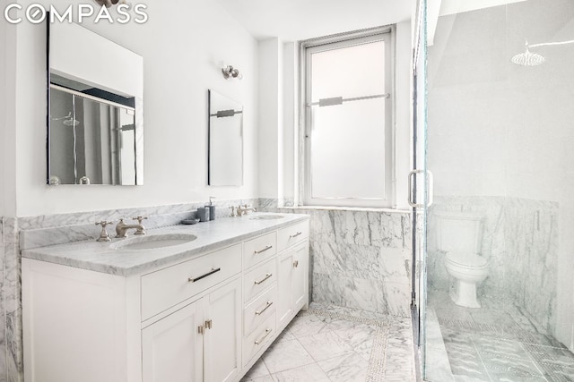 bathroom with a shower with shower door, tile walls, toilet, and vanity