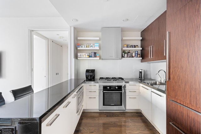 kitchen with appliances with stainless steel finishes, dark hardwood / wood-style floors, white cabinetry, sink, and island exhaust hood