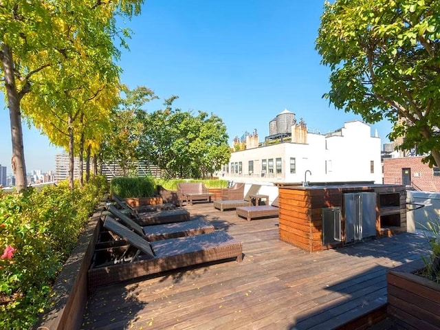 wooden deck with a view of city, an outdoor living space, and a sink