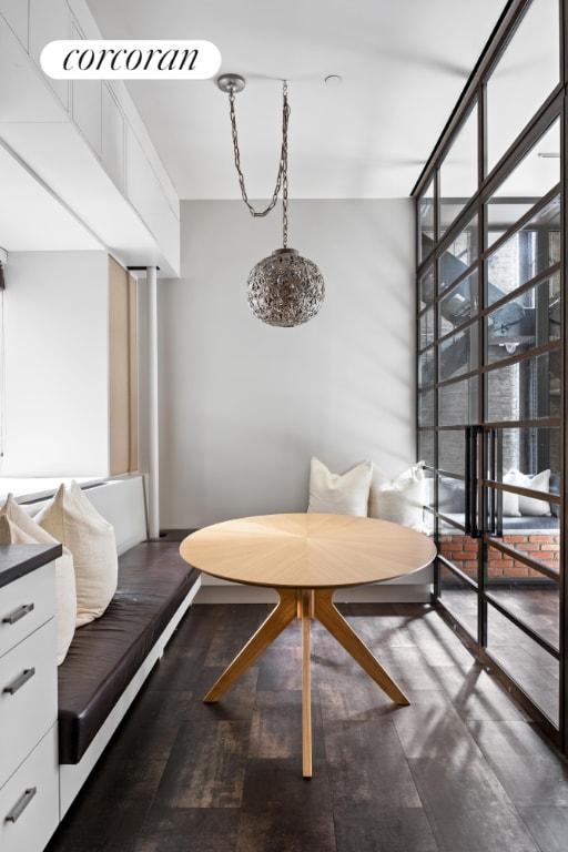 living area featuring breakfast area, a wall of windows, and dark hardwood / wood-style floors