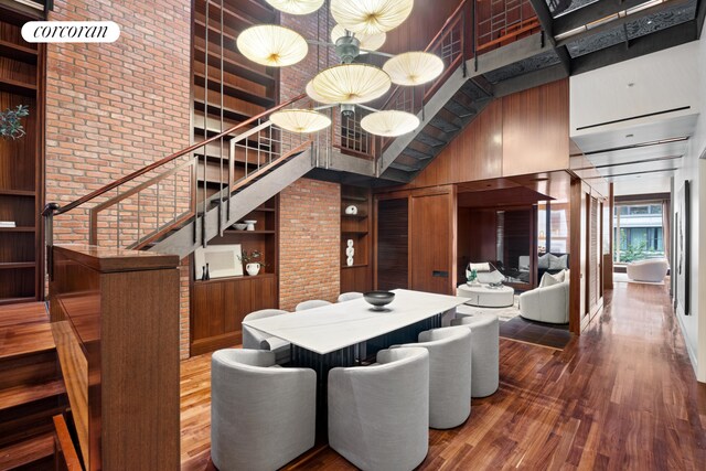 kitchen featuring white cabinetry, a center island with sink, built in appliances, and range hood