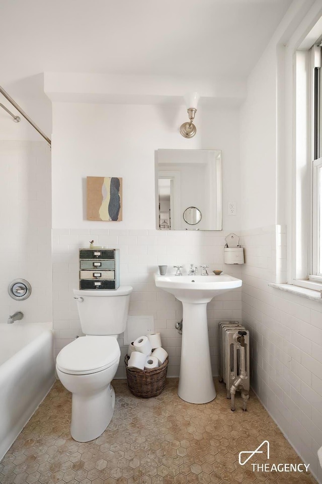 200 W 108th St Unit 15D, New York City, NY 10025 - full bathroom featuring radiator heating unit, toilet, tile walls, tub / shower combination, and a wainscoted wall