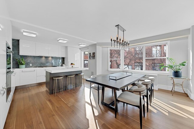 dining space with light wood-type flooring and a chandelier