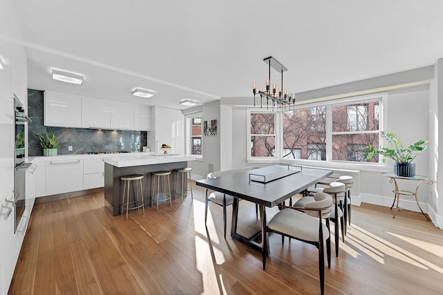 dining room featuring an inviting chandelier, wood finished floors, and baseboards