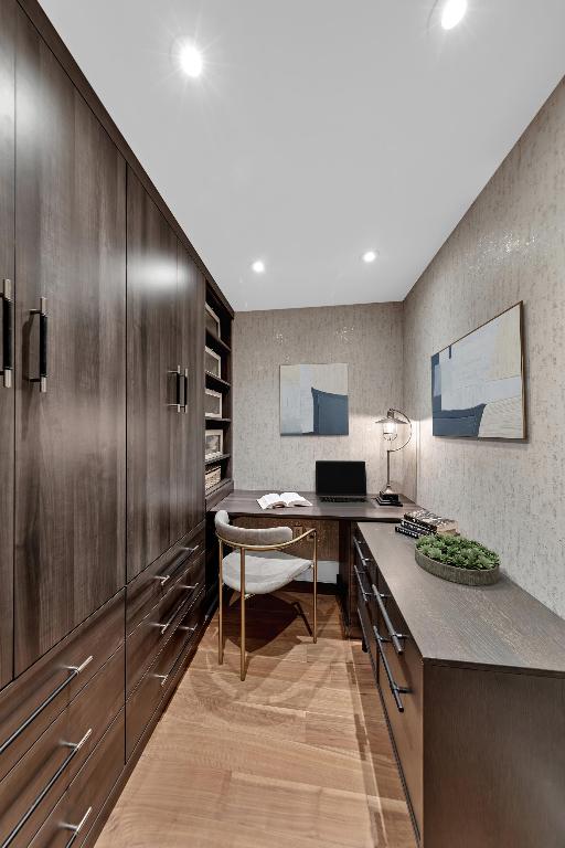 home office featuring built in desk and light hardwood / wood-style flooring