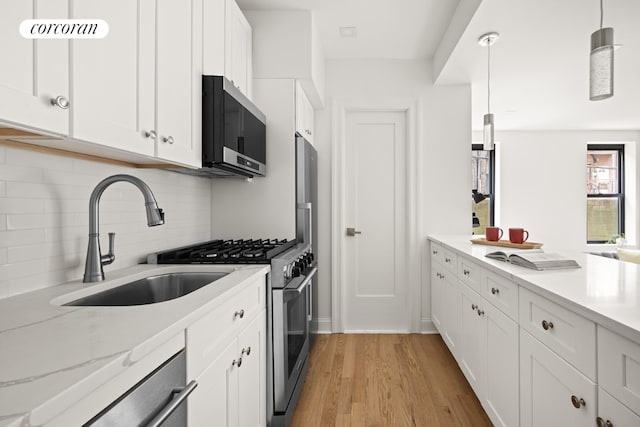 kitchen with white cabinets, hanging light fixtures, and appliances with stainless steel finishes