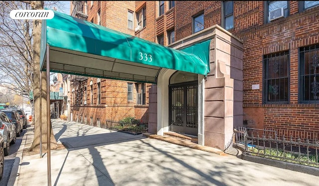 view of exterior entry with brick siding