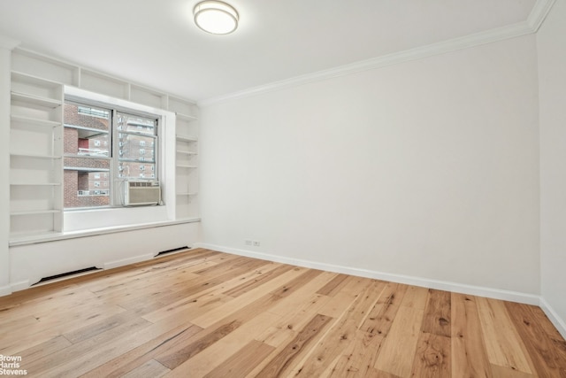 unfurnished room featuring ornamental molding, wood-type flooring, and baseboards