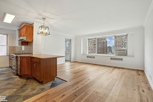 kitchen with brown cabinets, visible vents, decorative backsplash, stainless steel gas stove, and under cabinet range hood