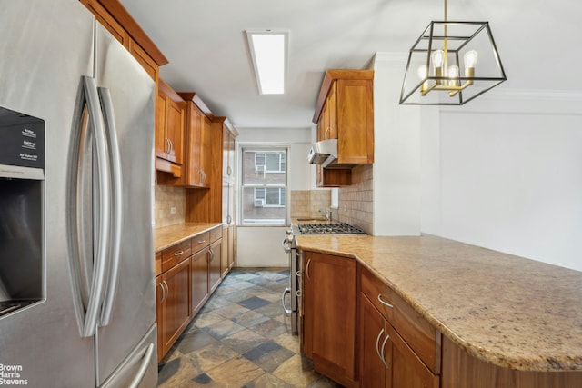 kitchen featuring stainless steel appliances, tasteful backsplash, stone finish floor, and under cabinet range hood