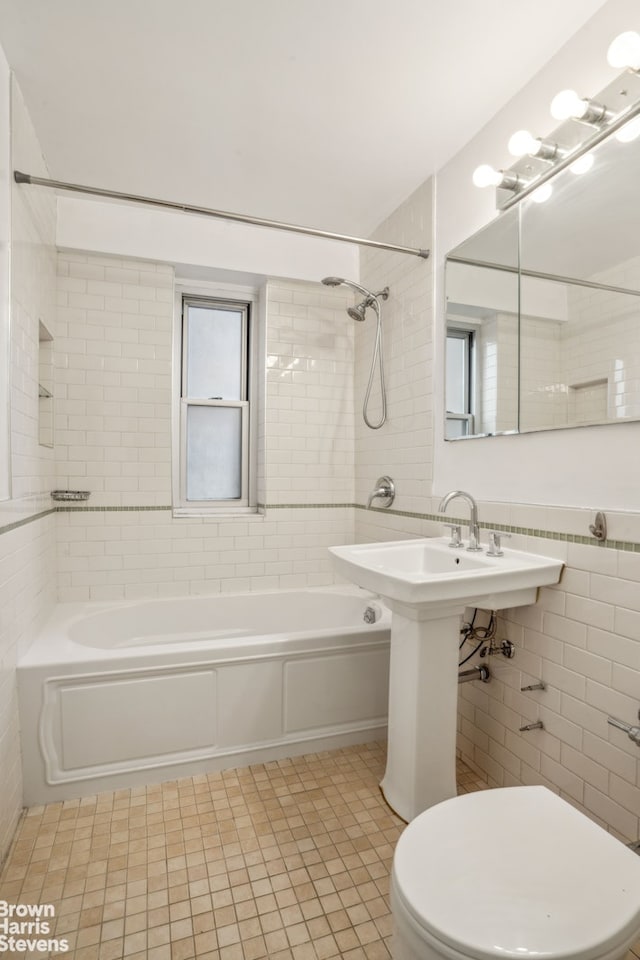 full bath featuring toilet, tub / shower combination, tile walls, and tile patterned floors