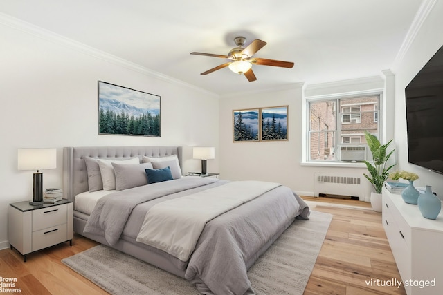 bedroom with light wood finished floors, radiator heating unit, a ceiling fan, and crown molding