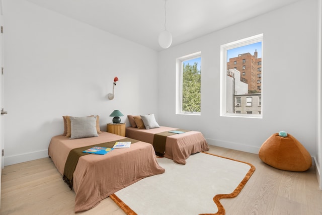 bedroom featuring light wood-style flooring and baseboards